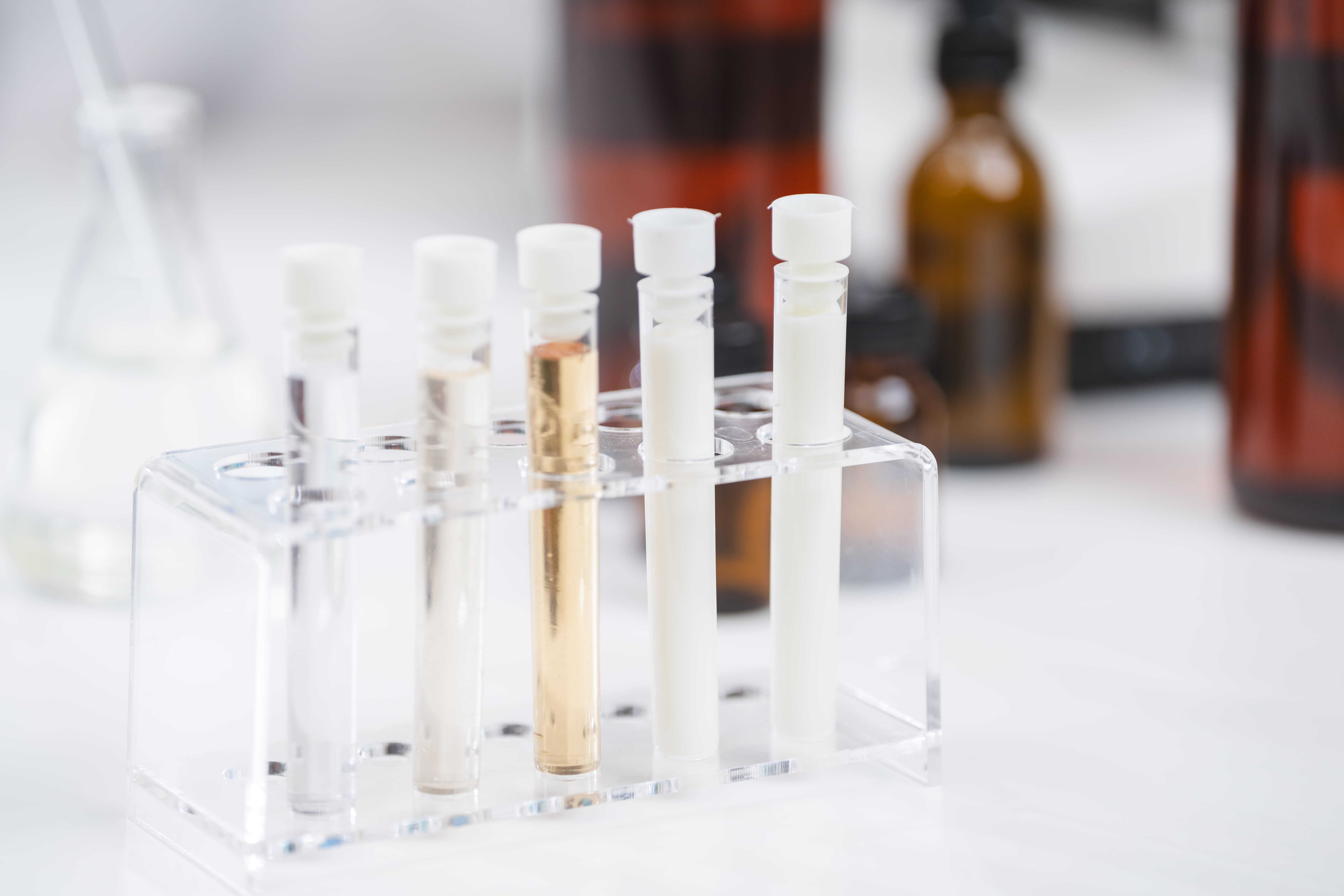 Food scientist testing new stuff samples of dairy products in the laboratory, female laboratory assistant checks a quality of milk, bottles glassware and glasses of milk to testing lactose forms